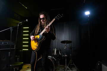 Fototapeta na wymiar Guitarist man plays an electric guitar Close-up at studio