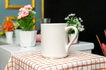 A white blank coffee mug on the top of a hand cloth with simple decorations arranged around it