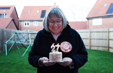 lady celebrating her 72nd birthday with a cake and candles