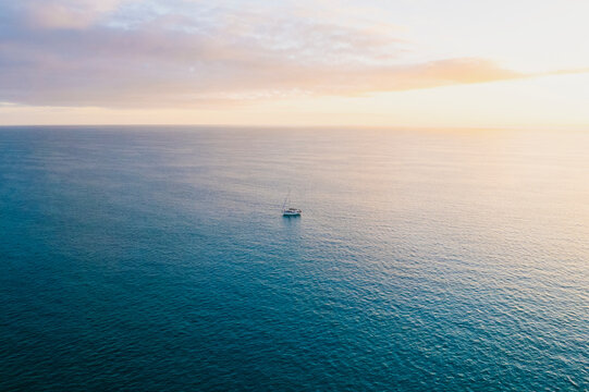 Aerial of Sailboat in Flat Calm Seas Anchored in the Bahamas at Sunset