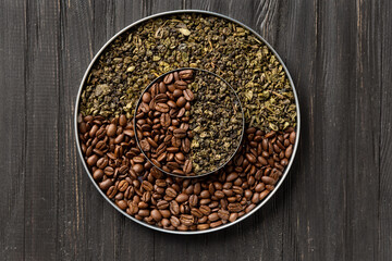 Green tea and coffee grains on a dark wooden background top view close-up.