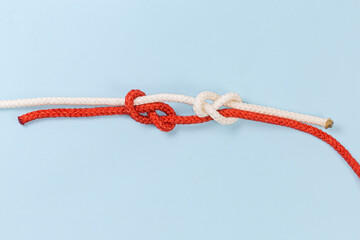 Not tightened rope fisherman knot on a blue background