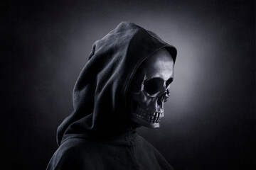 Grim reaper over dark misty background