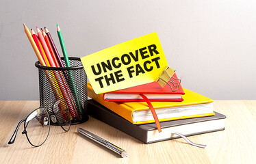 UNCOVER THE FACT written on a sticky on notebooks