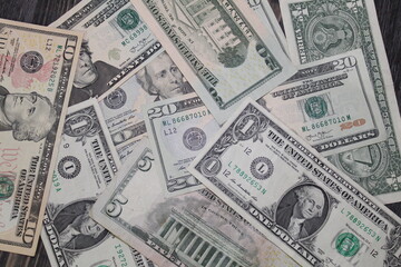 Multiple US dollar bills of different denominations scattered.