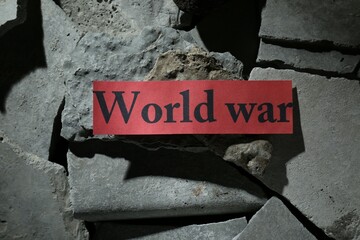 Paper with words World War on pieces of concrete, top view