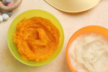 Baby food. Different tasty puree in bowls on beige textured table, flat lay