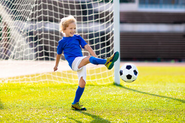 Kids play football. Child at soccer field.