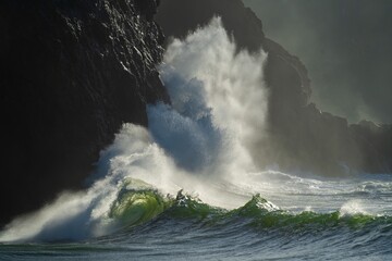 Huge wave crashing against a headland on the north Washington state  coast during a king tide