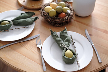 Festive Easter table setting with Easter bunny made of linen napkin and egg. Top view.