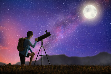 Young man looking at stars through telescope