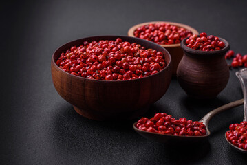 Spice, allspice peas of red or pink color in a wooden bowl