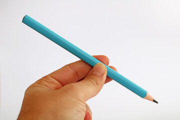 Hand holding triangular blue pencil isolated