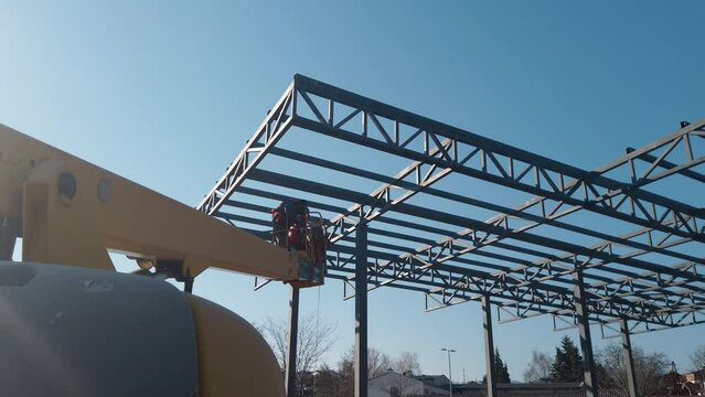 Steel worker operating cherry picker