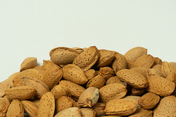 Whole almonds in shell closeup against white background.
