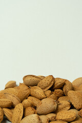Whole almonds in shell closeup against white background.
