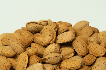 Whole almonds in shell closeup against white background.
