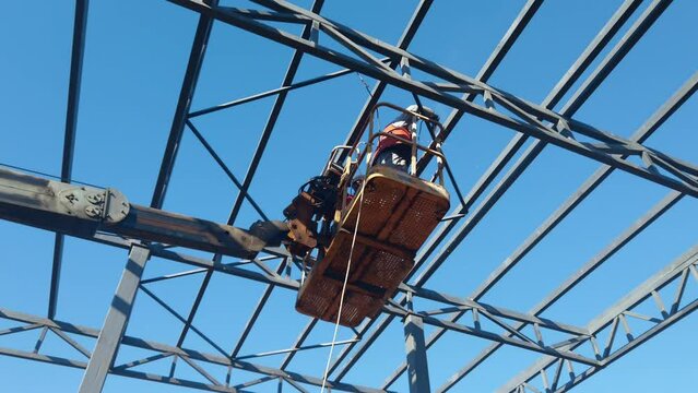 Steel worker operating cherry picker from cherry picker
