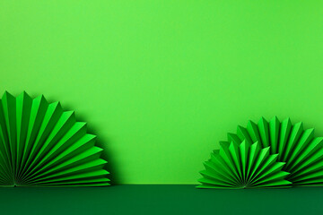 St Patricks Day paper fans on green background. Abstract, minimalist background for Saint Patrick's day banner design.