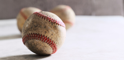 Sports nostalgia with texture of old used baseballs worn from game, copy space on blurred background of banner.