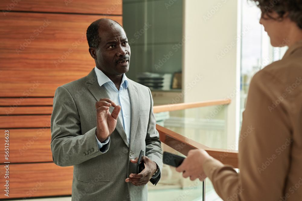 Aufkleber confident employer in formalwear giving instructions or explaining something to female manager at br