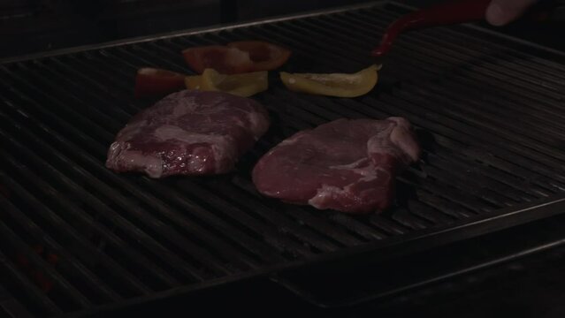 Cooking Beef Steak On The Grill Grate On Restrain Kitchen, Close Up. Hot Barbecue Charcoal Flaming Grill. Slow Motion.