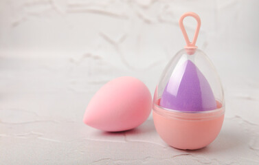 Beauty blender on light marble background. Cosmetics, makeup application tool. Beauty concept. Copy space. Place for text.