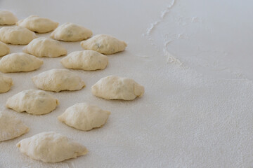 Fototapeta na wymiar Homemade buns with potatoes made from yeast dough on white countertop as they are being made