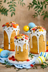 Traditional Easter cakes decorated with dried fruits, nuts and seeds and painted eggs on wooden background.  Homemade Orthodox dessert. Easter bread Kulich. Selective focus