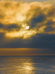 Aerial sunrise seascape with sun behind the fog and clouds