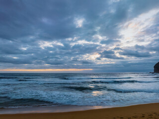 Fototapeta na wymiar Sunrise over the ocean with rain clouds