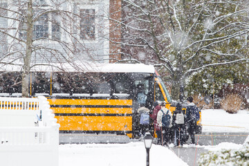 High School Students are Boarding School Bus in Blizzard Snow Storm at Lexington, MA on January 20, 2023 - obrazy, fototapety, plakaty
