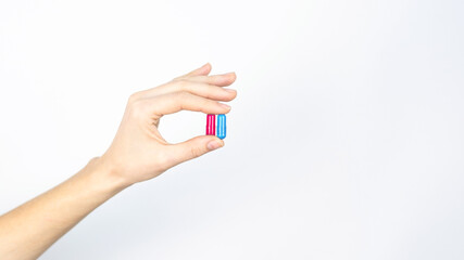 Hand holds red and blue pills isolated on white, Concept for Rational Drug Use
