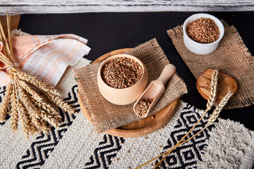 Fototapeta na wymiar Aesthetic superfood - buckwheat porridge. Healthy breakfast with cutlery made of natural cotton and wood. Natural background