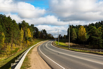 Smooth curve of a turning empty car road surrounded by pines