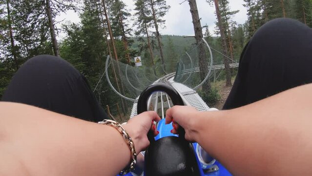 Rail downhill on a trolley roller coaster pov ride in the forest in blue trolley