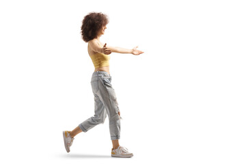Full length profile shot of a young woman with afro hairstyle walking to hug somebody