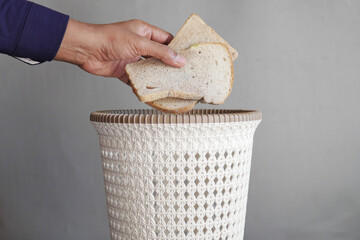 throwing old bread in a garbage bin 