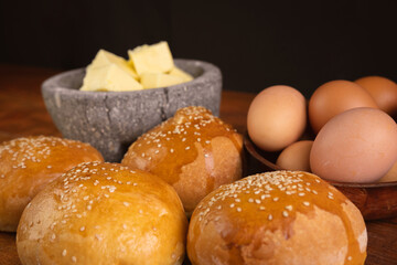 photography of homemade organic bread on the table with butter and eggs