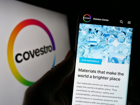 Stuttgart, Germany - 01-24-2023: Person holding cellphone with webpage of German chemicals company Covestro AG on screen in front of logo. Focus on center of phone display.