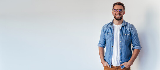 Isolated shot of young handsome man with beard, wearing casual clothes, posing in studio on white background