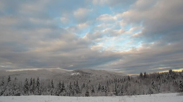 Winter mountain snowy landscape with beautiful clouds. Gorgeous time laps of the winter Carpathian mountains on a sunny winter day