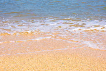 The coast of the Sea of Azov. Sea waves roll on the sandy shore. Seashell sandy beach.