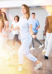 Fototapeta premium Smiling females and males doing dance workout during group classes in fitness center