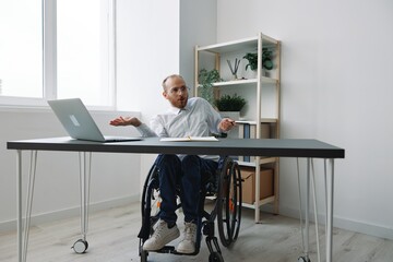 A man in a wheelchair a businessman in the office works, severe fatigue and emotional burnout,...