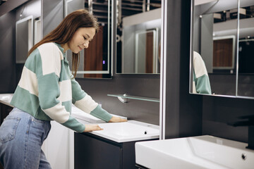 Fototapeta na wymiar Woman choosing bathroom sink in store