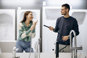 Couple in store choosing bathroom mixer