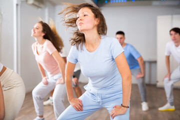 Group of smiling people of different ages dancing and practicing new movements in class. Sport,...
