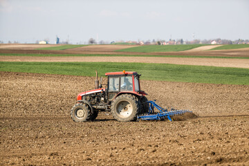 Obraz premium The promise of spring, tractor readying the fields for a new season of growth