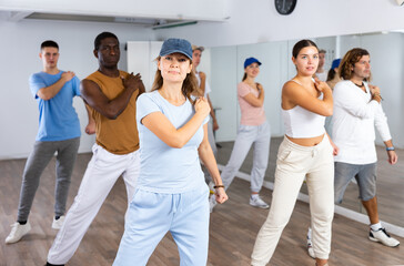 Fototapeta premium Group of positive dancers repeat dance in dance hall